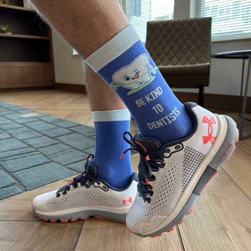 a pair of custom crew socks with a slogan saying be kind to dentists
