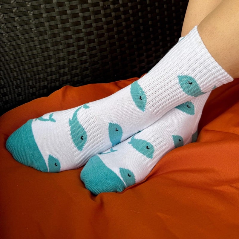 a pair of custom crew socks with blue whale pattern
