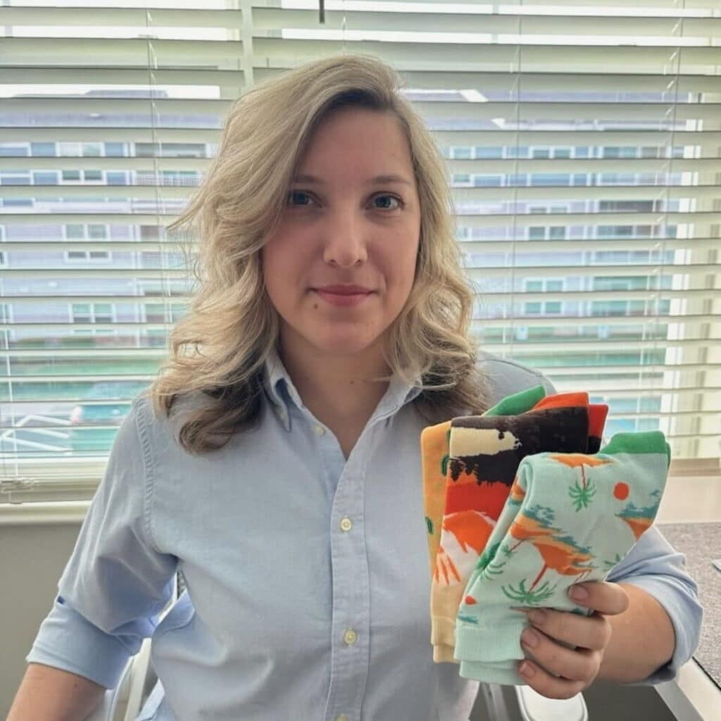 customer holding up several pairs of branded corporate socks by spirit sox