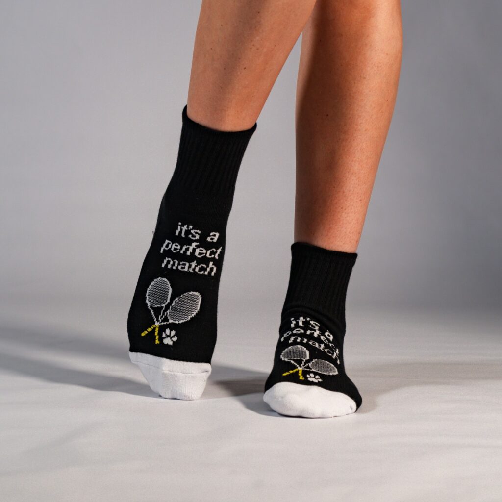 custom branded socks with black background, white toes, and calligraphic branded image and messages for a tennis sporting equipment brand