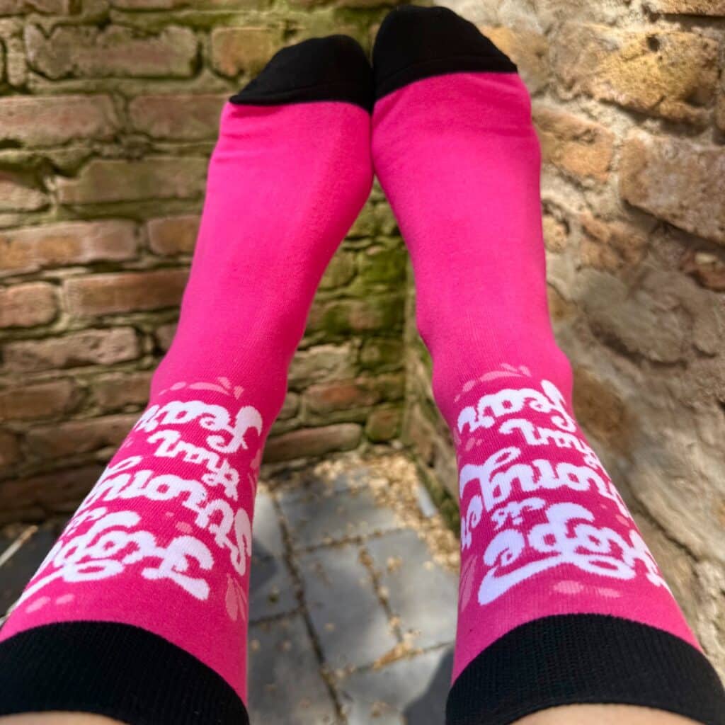a pair of pink branded socks with white logos by spirit sox usa