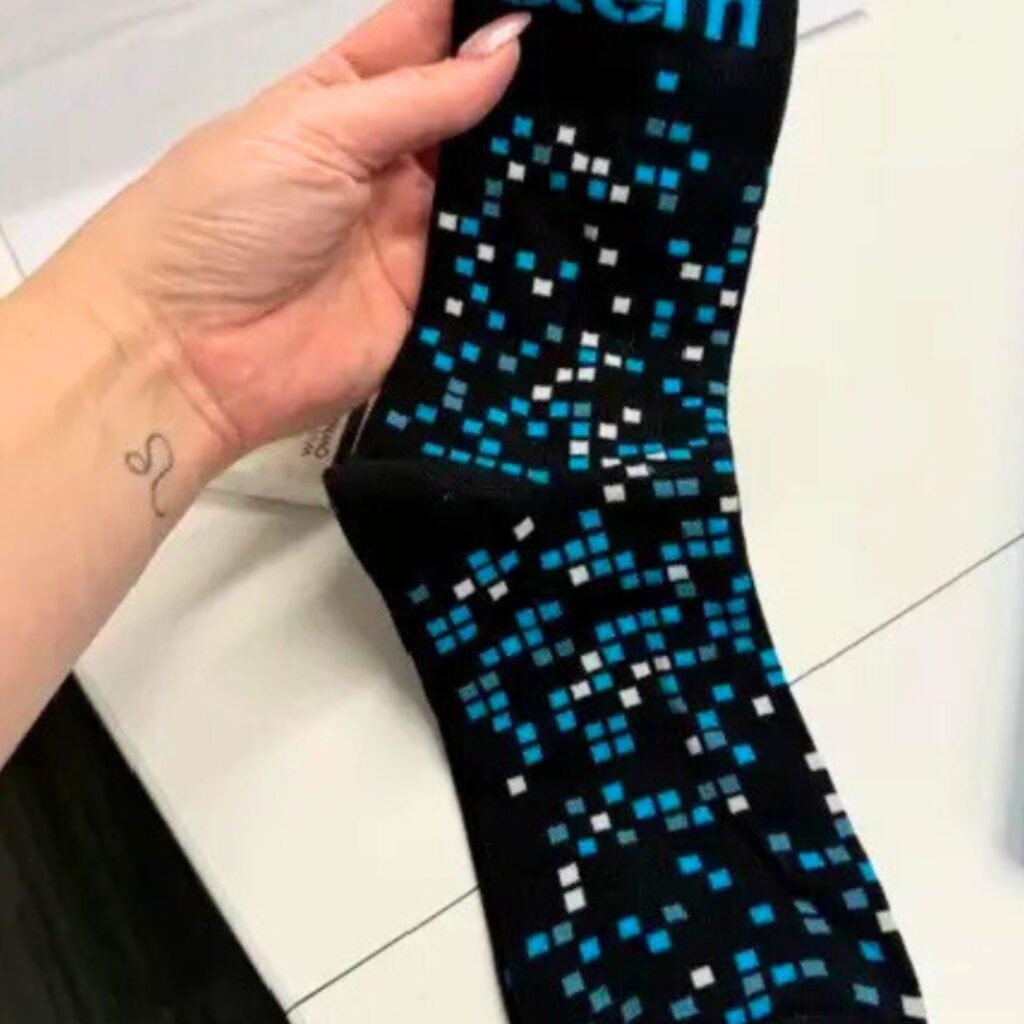 a pair of custom socks with digital abstract patterns on black background