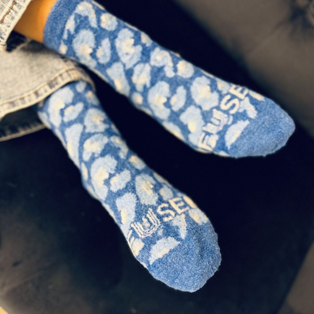 a pair of custom brand fuzzy sock with blue background and white cloud pattern by spirit sox
