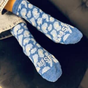 a pair of custom brand fuzzy sock with blue background and white cloud pattern by spirit sox