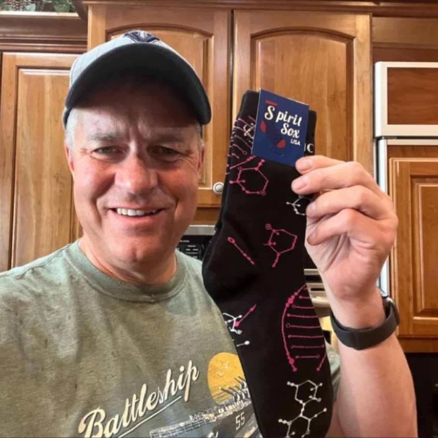 old man holding a pair of custom team socks with logo