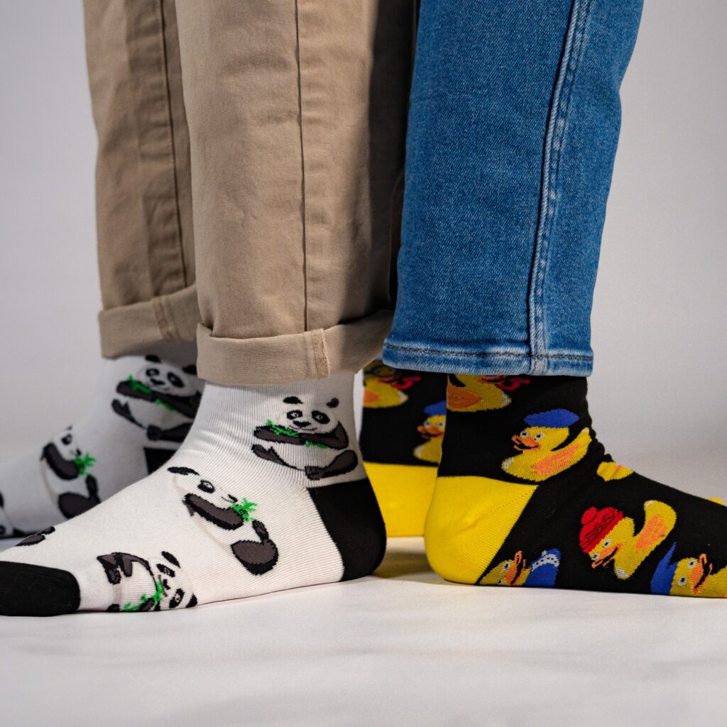 two people wearing custom design socks with pandas and rubber ducks standing back to back