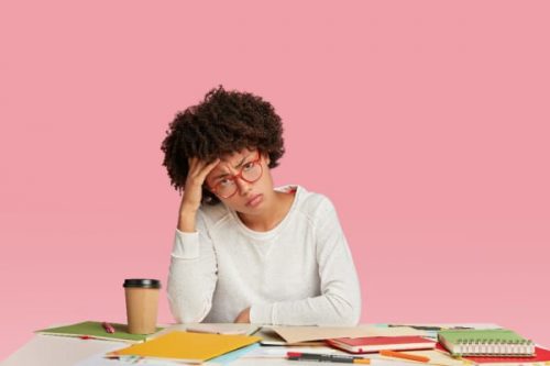 woman with hand on head and looking burnt out