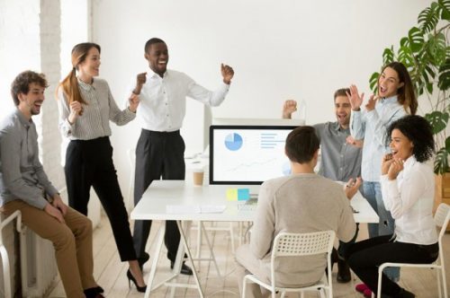 employees cheering in office setting
