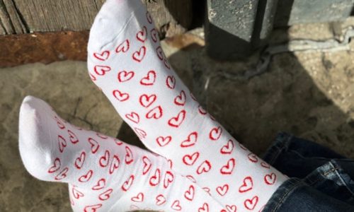 a pair of white cotton socks with red heart pattern from spirit sox